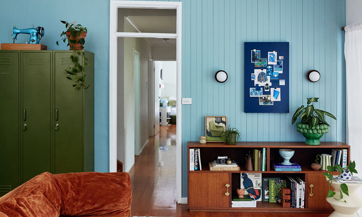 A living room with Ocean blue panelled walls, three Skinny lockers in Olive and a Navy Storyboard pinboard, styled in a 60-30-10 colour palette