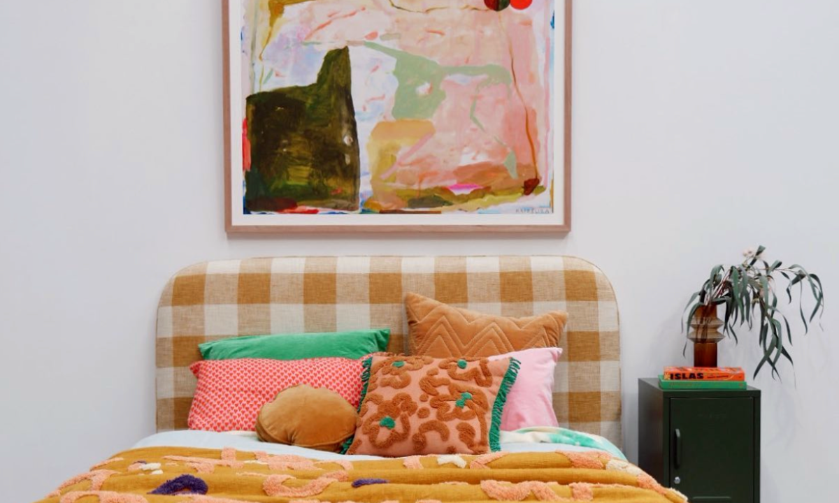 Colourful artwork hanging above a bed, a Mustard Made locker is beside the bed.