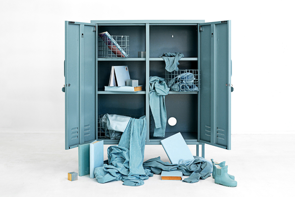 An Ocean Midi locker has both doors open to reveal a mess of Ocean coloured belongings spilling out on to the floor.
